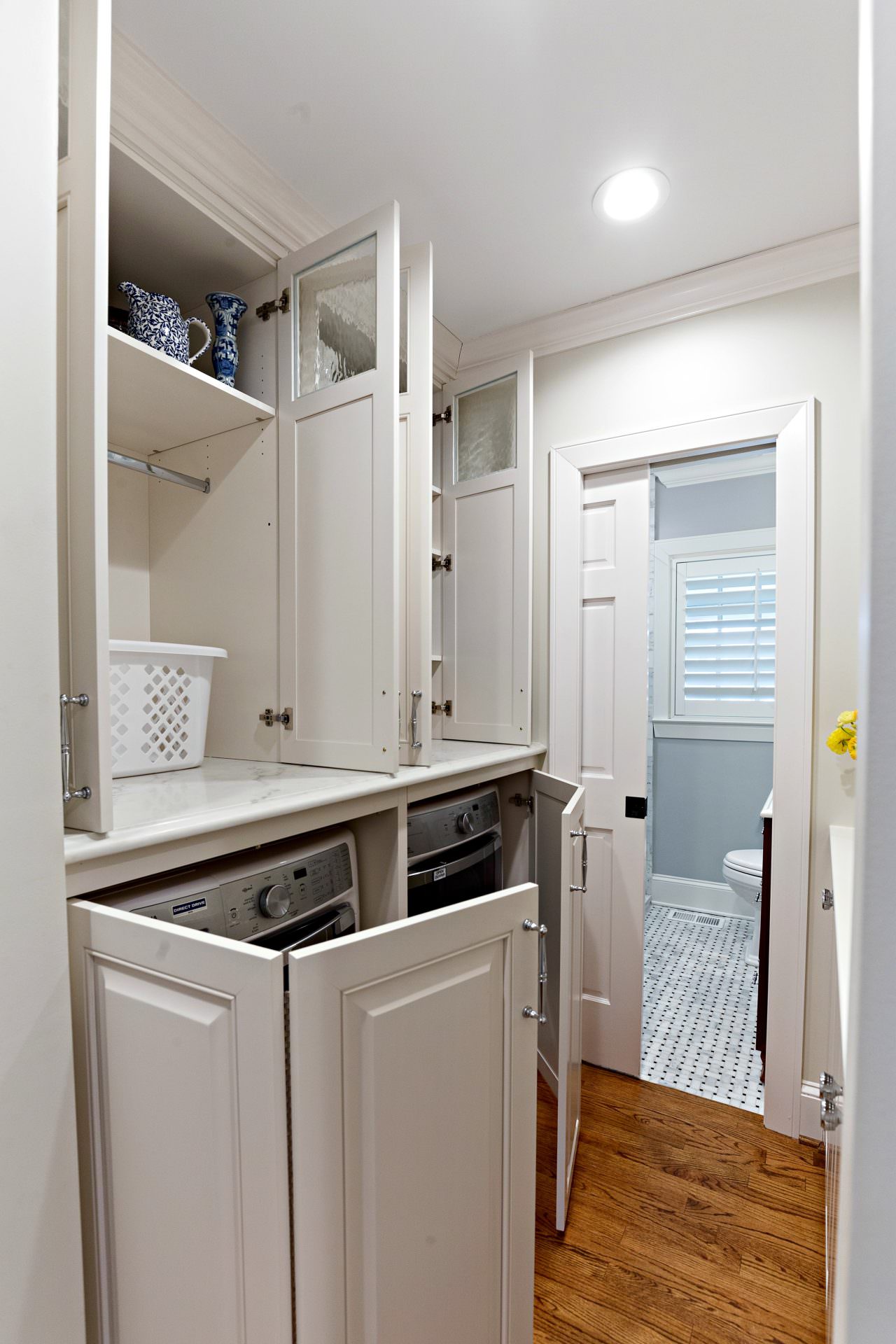 Walker Woodworking custom cabinets, white laundry room, custom storage 