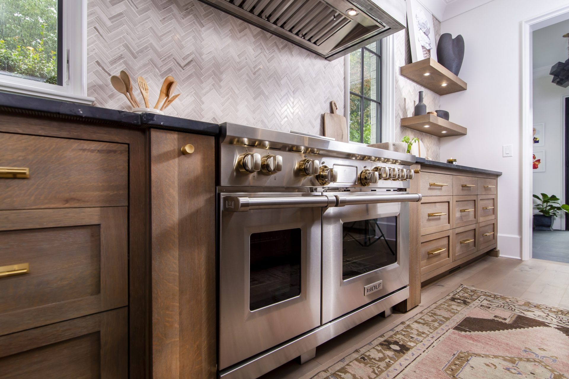 quarter sawn white oak kitchen cabinets with brass hardware and stainless steel kitchen stove with range hood