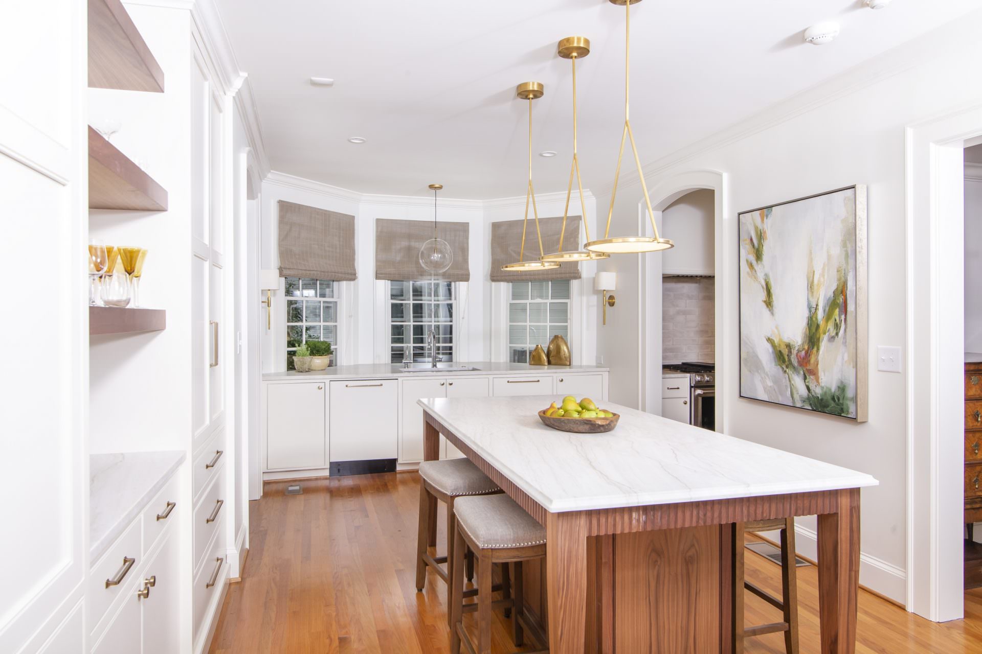 white kitchen with walnut island and white countertop and brass light fixtures